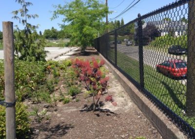 Black 4 foot tall, chain-link fence in retaining wall